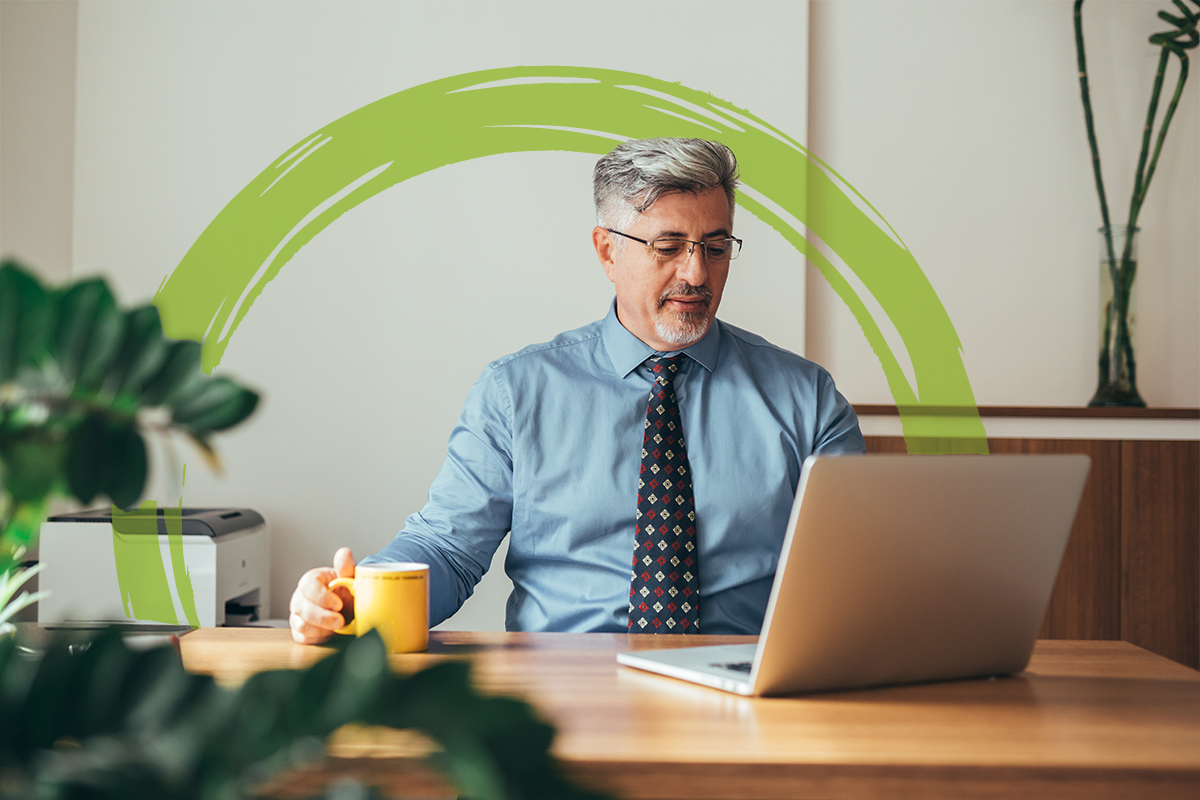 Middle aged man on computer in office morning with lime green brushstroke