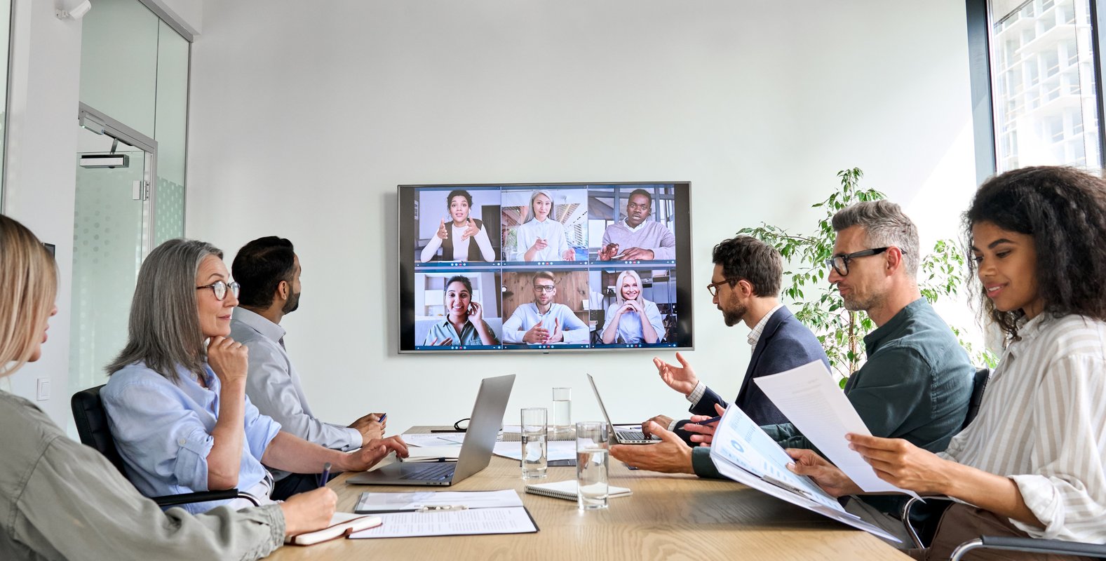 Team of professionals having an in-person and virtual meeting