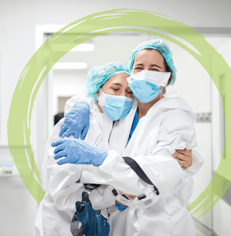 Two doctors hugging in PPE with green brushstroke - SQUARE