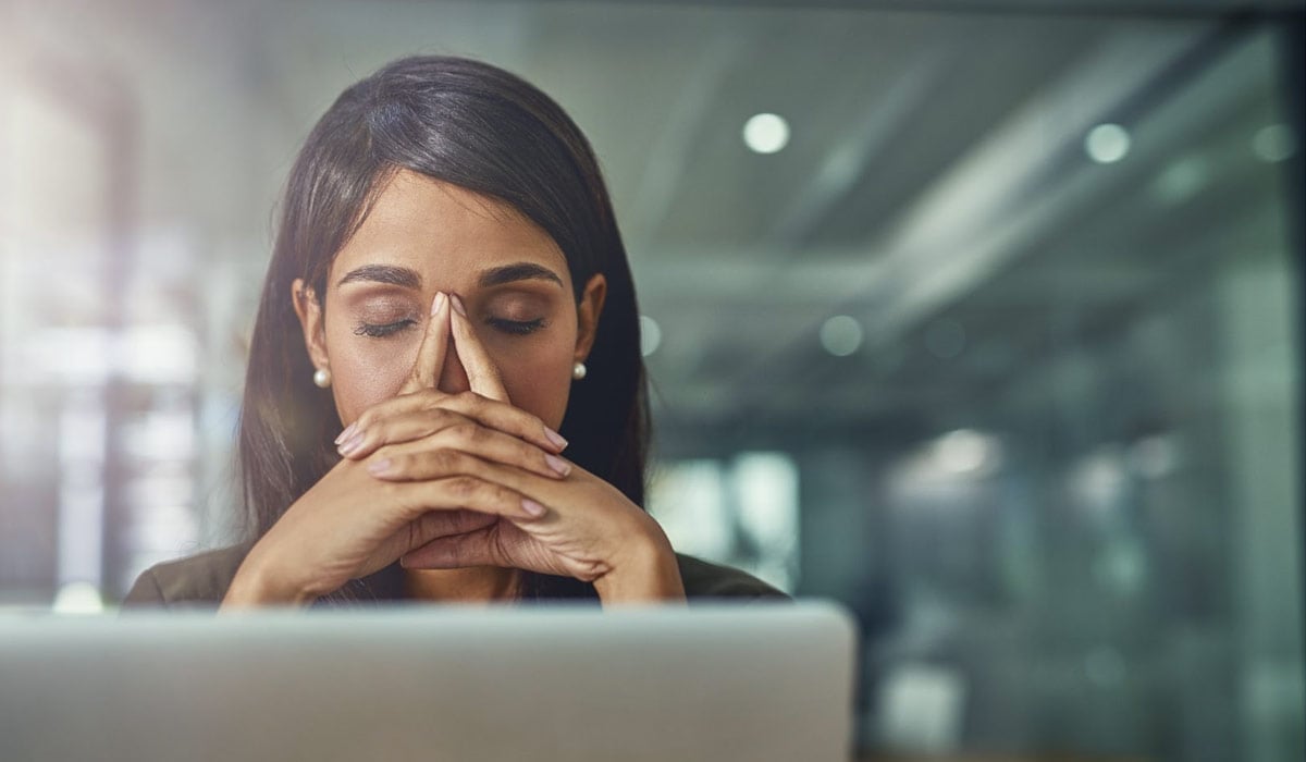 Woman Experiencing Burnout in front of a laptop